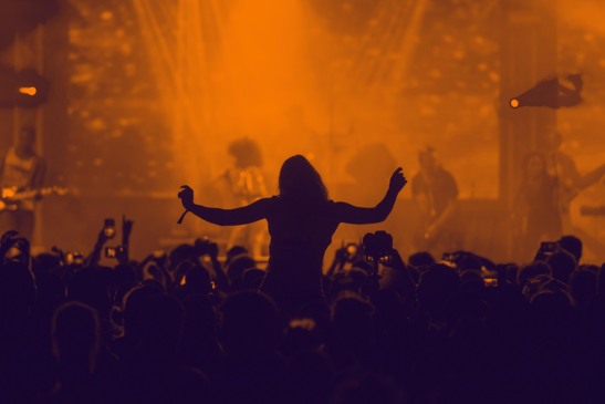 Plateia de show com mulher curtindo a banda