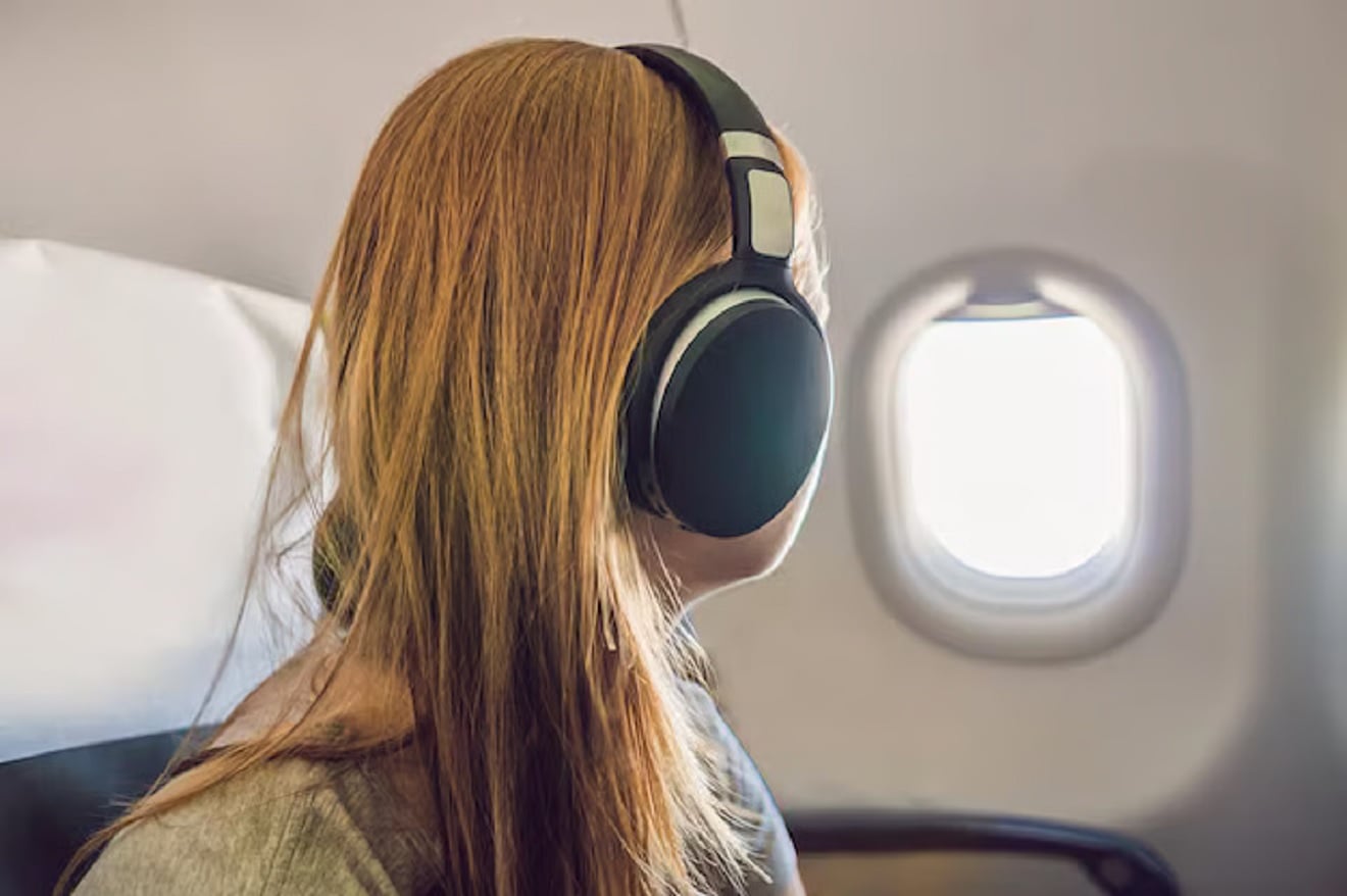 Mulher usando fones de ouvido em avião, fone de ouvido
